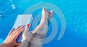 Girl reading by the swimming pool