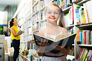 Girl reading textbook in bookstore