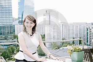 The girl reads a book overlooking the Palace of Culture in Warsaw, a business woman. The lady sits at the table, drinks coffee