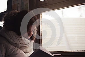 Girl reads a book in the train carriage