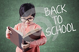 Girl reads a book with word of Back to School