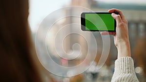 Girl recording video smartphone green screen outdoors. Woman using mock up phone