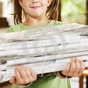 Girl recycling newspapers