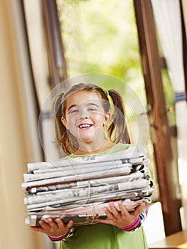 Girl recycling newspapers