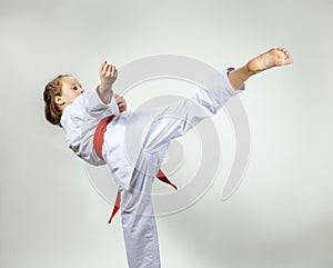 Girl with red belt strikes a high kick