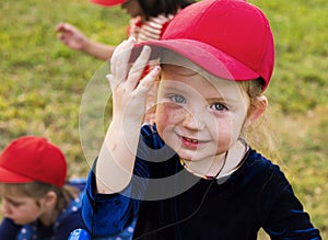 Girl with red cap is smiling to camera