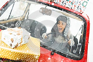 Girl in red car with Christmas gifts