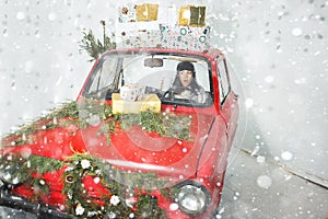 Girl in red car with Christmas gifts