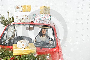 Girl in red car with Christmas gifts