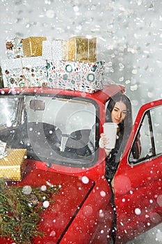 Girl in red car with Christmas gifts