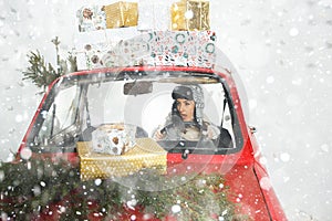 Girl in red car with Christmas gifts