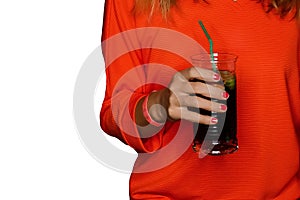 A girl in red clothes holds a glass of alcoholic beverage on white isolated background