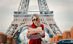 Girl in red coat and bag with map in parisian park