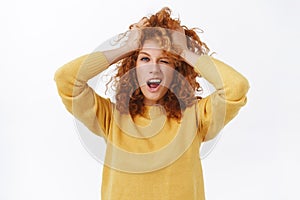 Girl with red curly messy hair, tousle hairstyle and making daring, sassy expression, enjoying her new color, change photo