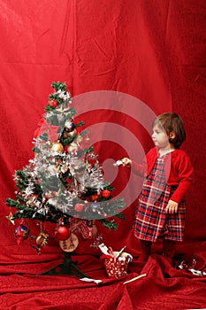 Girl in red and the decorated Christmas tree