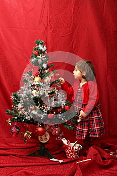 Girl in red and the decorated Christmas tree