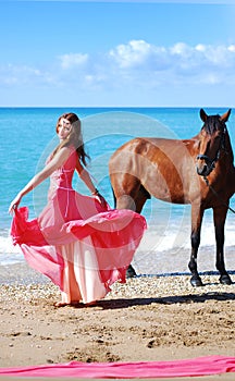 The girl in red dress dances on beach