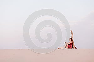 Girl in a red dress in the desert