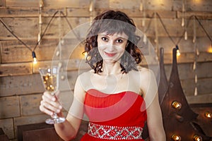 Girl in red dress with a glass of champagne, holidays, christmas and celebration concept - beautiful sexy woman in red dress with