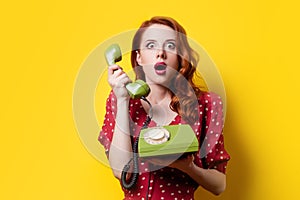 Girl in red dress with green dial phone