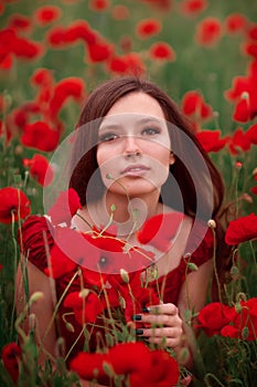 Girl in a red dress on a poppy field