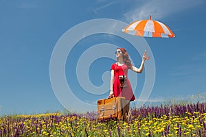 Girl in red dress with umbrella and suitcase
