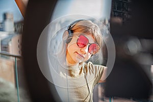 Girl with red glasses dances on balcony and broadcasts live