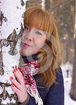 The girl with red hair in a birch forest