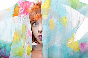 Girl with red hair and colorful dress over white