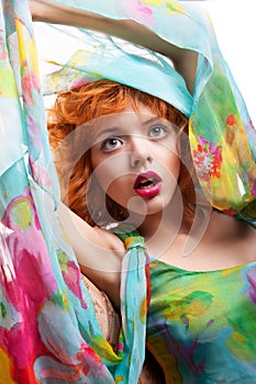 Girl with red hair and colorful dress over white