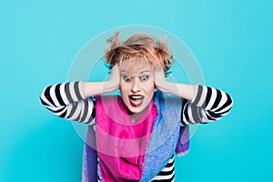 Girl with red hair holding her head shouting. Stress and hysterical. negative emotions. Studio shot.