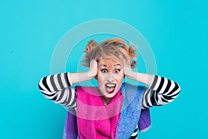 Girl with red hair holding her head shouting. Stress and hysterical. negative emotions. Studio shot.