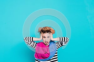 Girl with red hair holding her head shouting. Stress and hysterical. negative emotions. Studio shot.