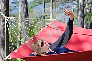 Girl in red hammock, woods