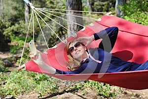 Girl in red hammock, woods