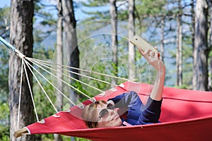 Girl in red hammock, woods