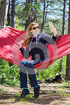 Girl in red hammock, woods