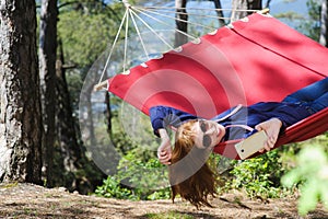 Girl in red hammock, woods