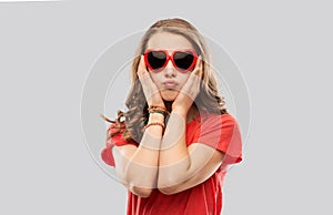 Girl in red heart shaped sunglasses pouting