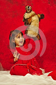 A girl in red hugging a small bad wolf marionette