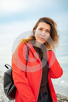 girl in a red jacket on the seashore