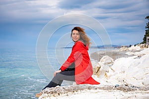 girl in a red jacket on the seashore