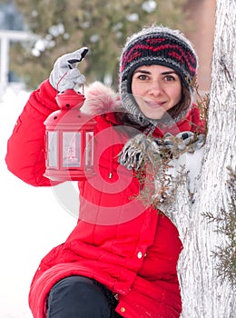 Girl with red lantern in the snow