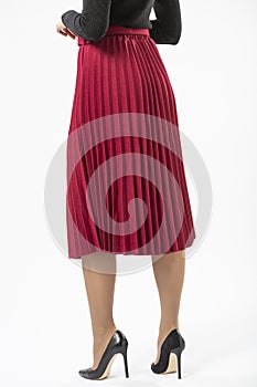 a girl in a red long ruffled skirt and black high heeled shoes isolated