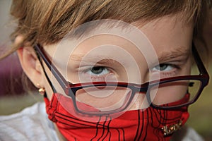 A girl in a red mask and glasses. A hurt child
