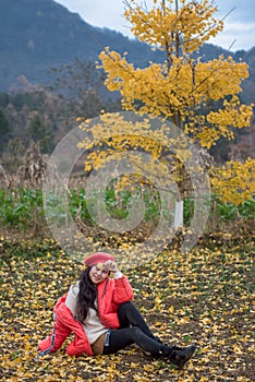 The girl in red overlie with ginkgo leaf