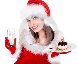 Girl in red Santa hat eating cake on plate.