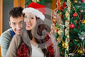 Girl in red Santa hat and her boyfriend smiling