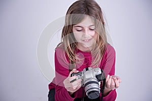 Girl in red shirt holding old camera and smiling