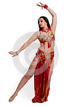 Girl in a red suit oriental dance in motion isolated on white